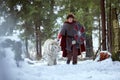 Medieval warrior walks with white tiger in forest