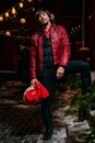 Man dressed as Santa Claus poses on a street decorated with garlands. New Year and Christmas concept