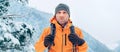 Man dressed bright orange softshell jacket with backpack have trekking on the winter mountains route. Active people or survival in Royalty Free Stock Photo