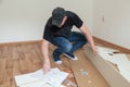 Man dressed casual assembling furniture in new house. Carpenter repair and assembling furniture at home