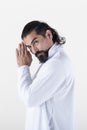 A man dressed in white clasping hands while looking at camera over white background. .Tadasana yoga pose Royalty Free Stock Photo