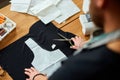 Man dressmaker cutting material with scissors on table, male tailor working in atelier,