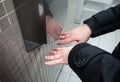 Man dries wet hands with an electric hand dryers