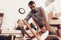 Man with Drill in Hands Repairing Chair on Floor. Royalty Free Stock Photo