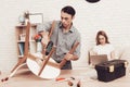 Man with Drill in Hands Repairing Chair in Room. Royalty Free Stock Photo