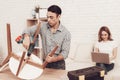 Man with Drill in Hands Repairing Chair in Room. Royalty Free Stock Photo