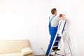 Man with drill working on ladder Royalty Free Stock Photo