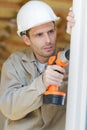 Man drilling hole in window frame Royalty Free Stock Photo
