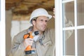 Man drilling hole in window frame Royalty Free Stock Photo