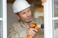 man drilling hole in window frame Royalty Free Stock Photo