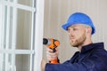 Man drilling hole in window frame Royalty Free Stock Photo