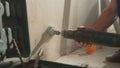 Man drilling round hole in concrete wall for socket. Builder drills hole with rotating electric drill or perforator