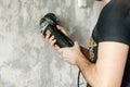 A man is drilling a wall. The concept of construction work, repair with their own hands, finishing work Royalty Free Stock Photo