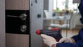 A man drills a doorway  a handyman repairs or repairs the lock of a wooden door of an apartment. Home renovation worker Royalty Free Stock Photo