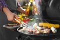 Man with drink cooking meat and vegetables on barbecue grill outdoors, closeup Royalty Free Stock Photo