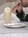 A man drink a glass of coconut smoothy at the coffee cafe.