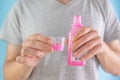 Man drinking antacid syrup to treat gastritis, stomach ulcer, heartburn, acid indigestion from measuring cup. Taking Royalty Free Stock Photo