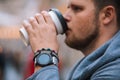 man drinking coffee from disposable cup smart watch with bracelet on wrist Royalty Free Stock Photo