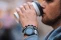 man drinking coffee from disposable cup smart watch with bracelet on wrist Royalty Free Stock Photo