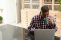 Man drinking coffee while using laptop on worktop in kitchen Royalty Free Stock Photo