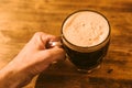 Man drinking dark beer in british dimpled glass pint mug