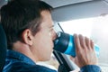 Man drinking hot coffee from thermo mug in a car Royalty Free Stock Photo