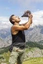 Man drinking red wine from a wineskin in the mountains. Royalty Free Stock Photo