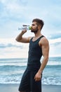 Man Drinking Refreshing Water After Workout At Beach. Drink Royalty Free Stock Photo