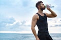 Man Drinking Refreshing Water After Workout At Beach. Drink Royalty Free Stock Photo