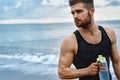 Man Drinking Refreshing Water After Workout At Beach. Drink Royalty Free Stock Photo