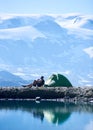 Man drinking tea near tent in mountains. Royalty Free Stock Photo