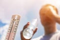 Man drinking water in extreme heat, Thermometer in summer day shows or indicate high temperature