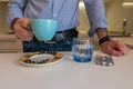 Man drinks coffee and glass of water to take pills