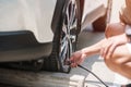 Man driver hand inflating tires of vehicle, removing tire valve nitrogen cap for checking air pressure and filling air on car Royalty Free Stock Photo