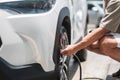 Man driver hand inflating tires of vehicle, removing tire valve nitrogen cap for checking air pressure and filling air on car Royalty Free Stock Photo