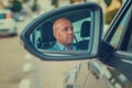 Man driver in his car looking to the road side view mirror reflection Royalty Free Stock Photo