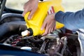Man driver pouring and refueling oil quality into the engine motor car, closeup