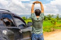 Man driver is stretching after a long road trip drive to relieve her back pain Royalty Free Stock Photo