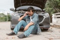 Man driver is using a mobile phone to call for help after car breakdown. Royalty Free Stock Photo