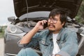 Man driver is using a mobile phone to call for help after car breakdown. Royalty Free Stock Photo