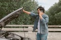 Man driver is using a mobile phone to call for help after car breakdown. Royalty Free Stock Photo