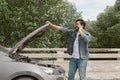 Man driver is using a mobile phone to call for help after car breakdown. Royalty Free Stock Photo