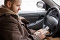 Man driver using smart phone in car, internet technology communication on road Royalty Free Stock Photo