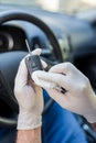 Man driver wearing protective gloves and cleaning car key with wet wipe Royalty Free Stock Photo