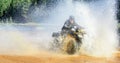 Man driving ATV quad through splashing water with high speed. Royalty Free Stock Photo