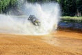 Man driving ATV quad through splashing water with high speed. Royalty Free Stock Photo