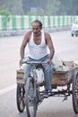 Man driving a bicycle rickshaw in New Delhi, India