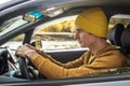 Man is driving a car along the river and the beautiful autumn forest. Concept of nature, travel and autumn mood