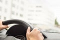 Man driving car in city. Driver holding steering wheel.