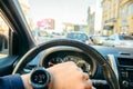 Man driving car in city traffic looking on watch. first person view Royalty Free Stock Photo